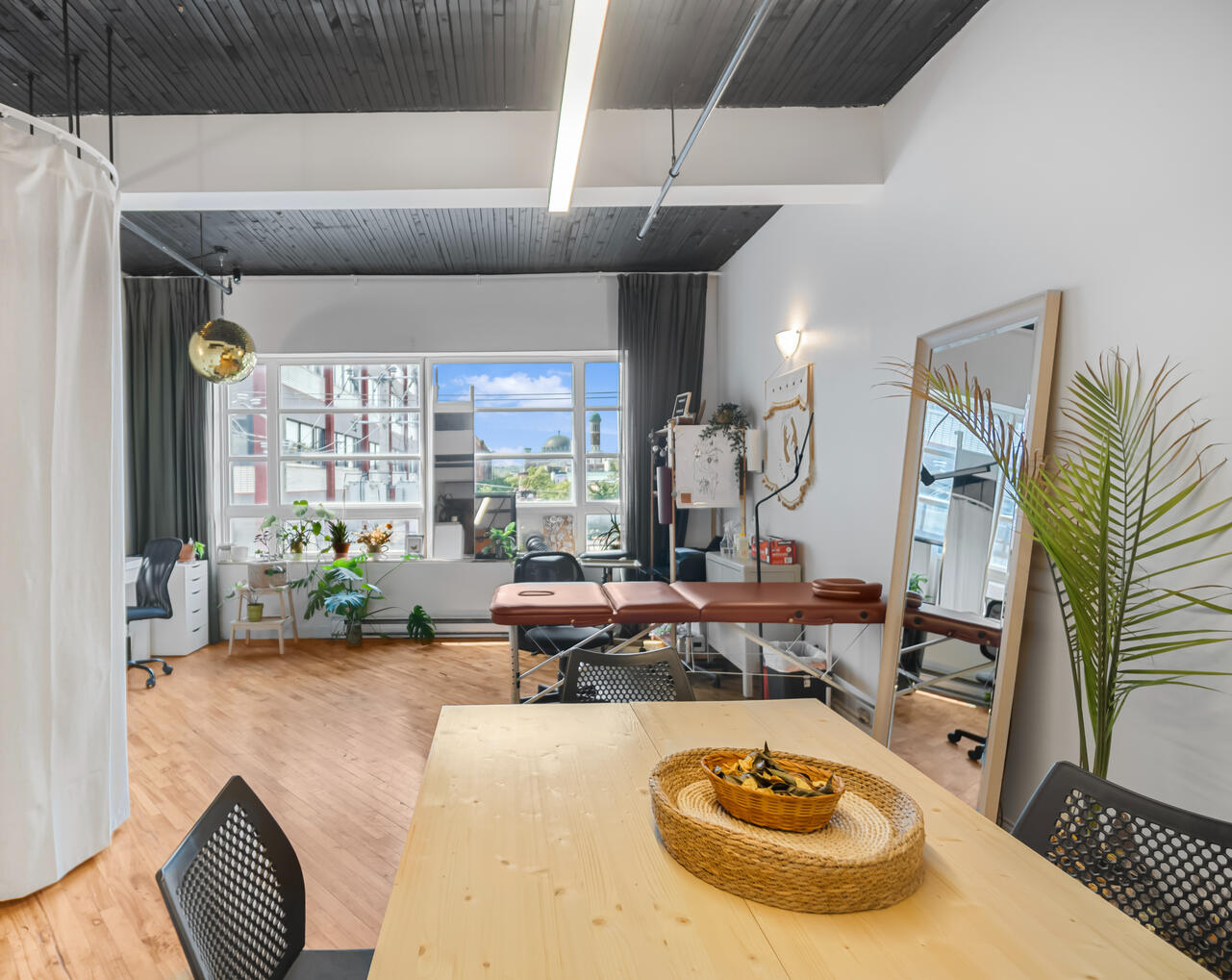 Pièce ouverte avec grandes fenêtres, espace de travail et mobilier dans un loft