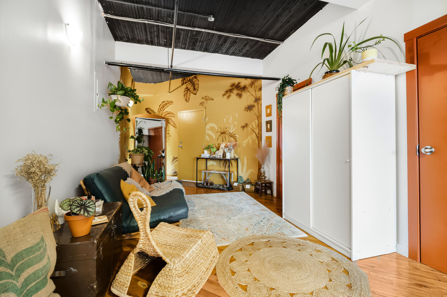 Salon éclectique avec plantes, mur jaune et mobilier dans un loft montréalais