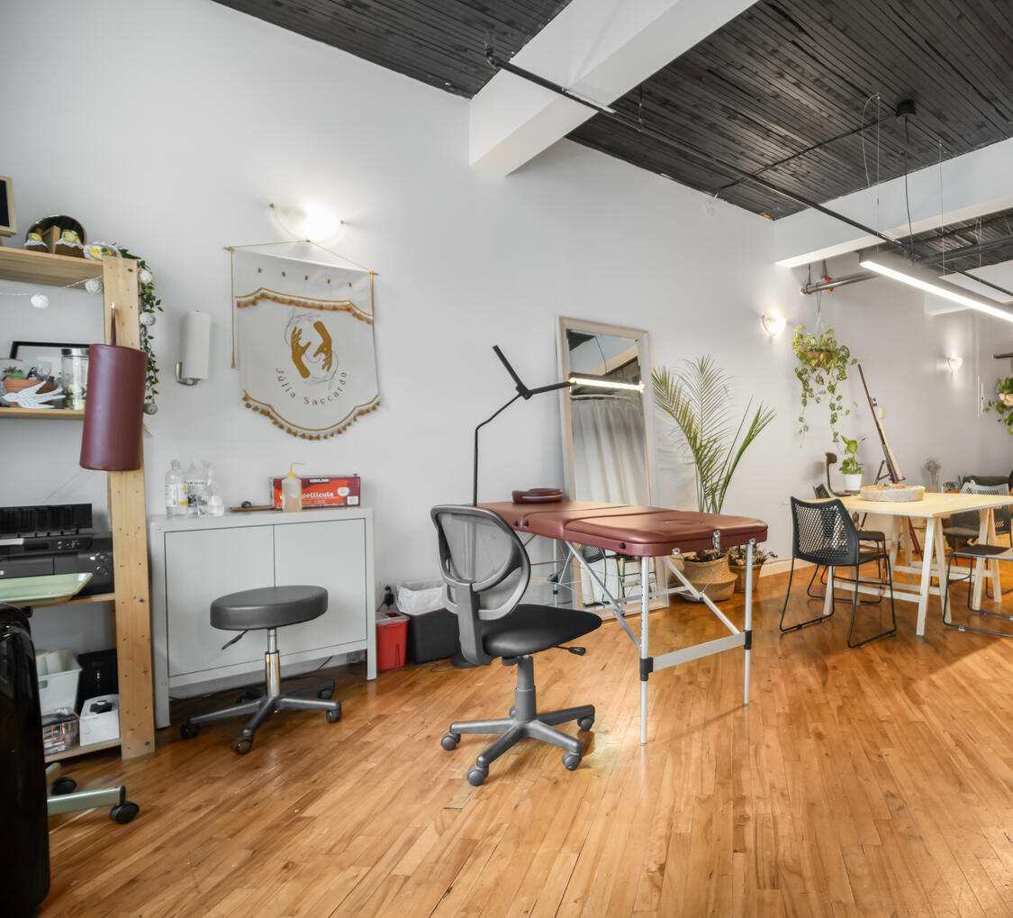 Espace de travail avec bureau, chaises et plancher de bois dans un intérieur lumineux